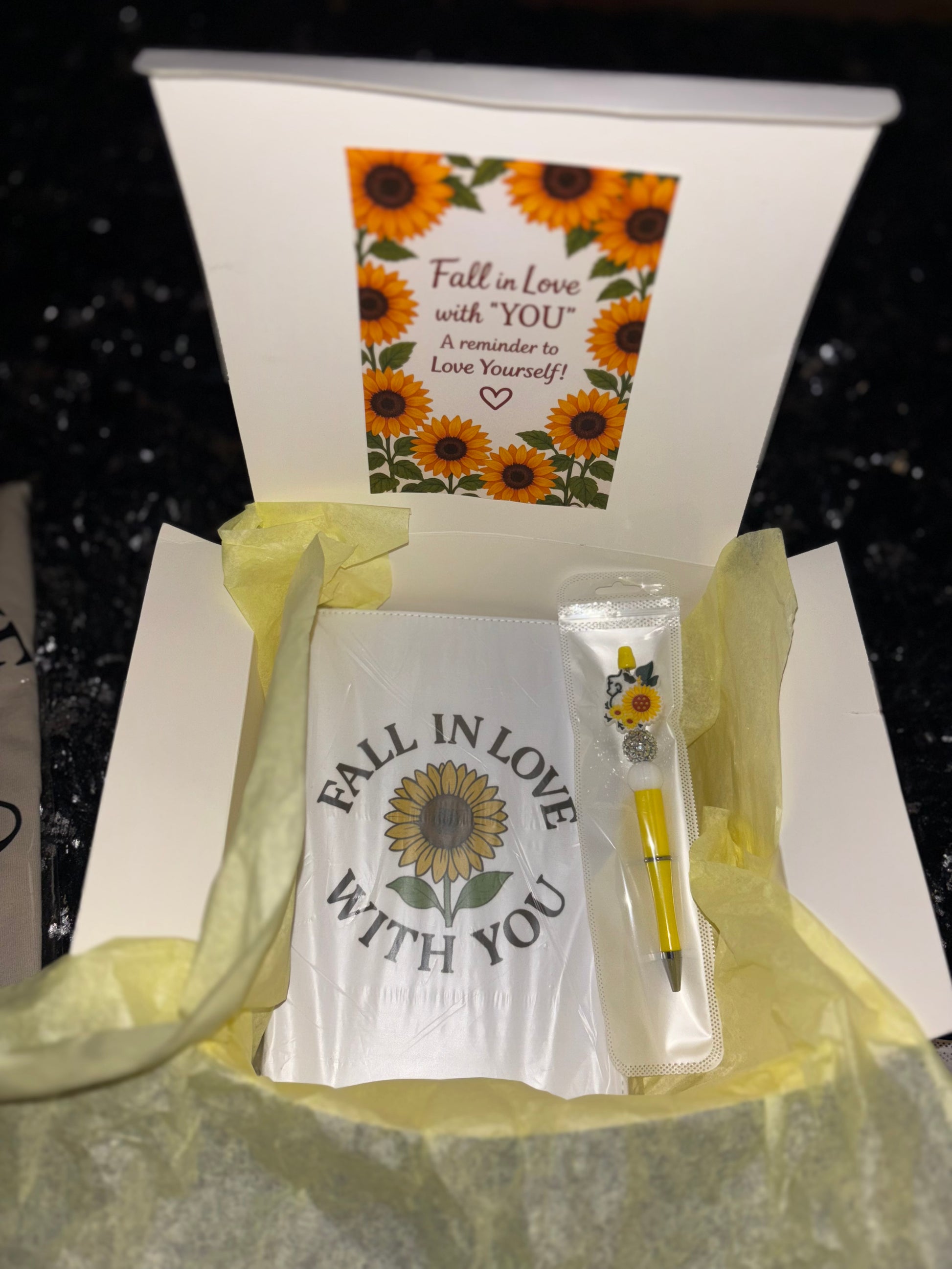 Gift set with a card, pen, and small container in a box with sunflower design.