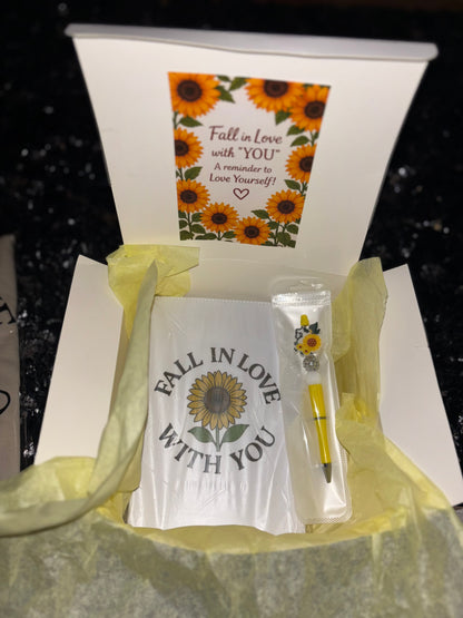 Gift set with a card, pen, and small container in a box with sunflower design.